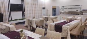a dining room with tables and chairs and a large window at ADJ Royalty Hotel & Suites in Benin City