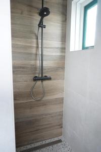 a shower in a bathroom with a wooden floor at Kustverhuur, Park Schoneveld, Zeemeeuw 138 in Breskens +12 photos