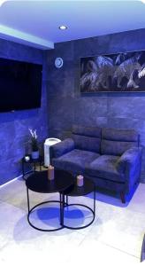 a living room with a couch and two tables at Love room in La Celle-sous-Gouzon