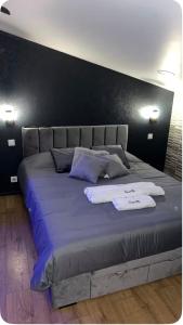 a large bed with two white towels on it at Love room in La Celle-sous-Gouzon