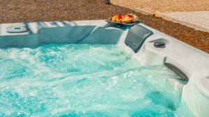 a hot tub with a bowl of fruit in it at Villa Paradise - Moradia tranquila com piscina aquecível e BBQ - Albufeira in Lagoa