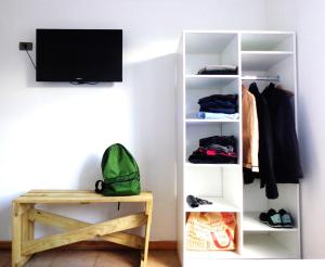 a white book shelf with a television in a room at Apart Hotel Endurance in Punta Arenas