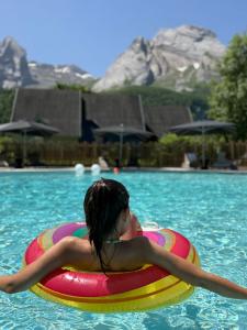 a woman floating on a raft in a swimming pool at ISKÖ CHALETS-HÖTEL, Col d'Aubisque in Gourette
