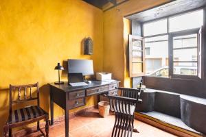 an office with a desk with a laptop and two chairs at Casa la Moringa in Los Silos