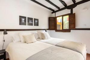 a bedroom with two beds with white sheets at Casa la Moringa in Los Silos