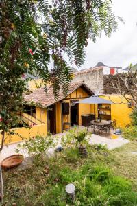 a yellow house with a table and chairs in a yard at Casa la Moringa in Los Silos