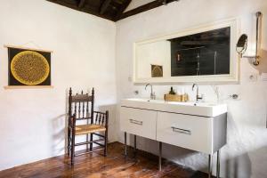 a bathroom with a white sink and a chair at Casa la Moringa in Los Silos +32 photos