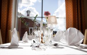 a table with glasses and napkins on a table with a window at Hotell Moskogen in Leksand