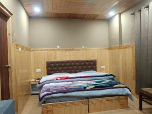 a bed in a room with wooden walls at Hotel Lake view in Nako