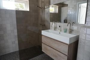 a bathroom with a sink and a shower at Kustverhuur, 't Uusje Nieuwvliet in Nieuwvliet +13 photos