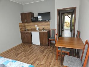 a kitchen and dining room with a table and a sink at Penzion u Vinice in Sedlec