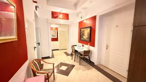a hallway with a table and chairs and red walls at Hotel Stadtpark in Vienna