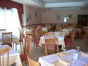 una sala da pranzo con tavoli e sedie con tovaglie bianche di Hotel Margherita a San Giovanni Rotondo