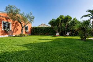 a lawn with two benches in a yard at Borgo Dragani in Ortona