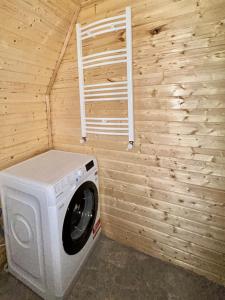 a washing machine in a room with a wooden wall at Cottage GORDA Kazbegi in Akhalts'ikhe