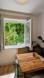 a dining room with a wooden table and a window at Gesztenyés Backpackers in Kőszeg +17 photos