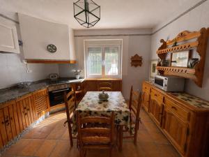 a kitchen with a table and a table and chairs at Casa Rural Mandala Riópar in Riópar
