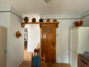 a kitchen with a wooden door and a refrigerator at Casa Rural Mandala Riópar in Riópar +11 photos