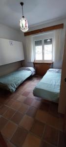 a bedroom with two beds and a window at Casa Rural Mandala Riópar in Riópar
