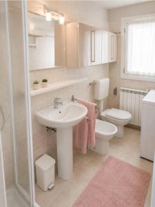 a bathroom with a sink and a toilet and a shower at Casa Incanto - Agenzia Cocal in Caorle