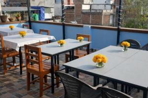 a row of tables and chairs with flowers on them at Second Home Hotel in Kathmandu