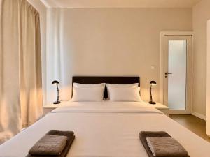 a bedroom with a large white bed with two pillows at Charming flat off the sea front in Il-Gżira