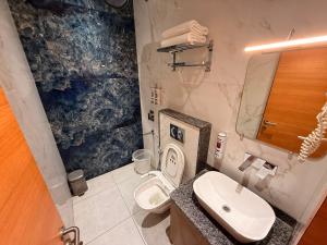 a bathroom with a sink and a toilet at Hotel Rosewood in Prayagraj