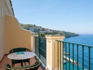 a balcony with a table and a view of the ocean at Hotel du Tasso Sorrento in Sorrento