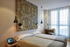sypialnia z dwoma łóżkami i dużym oknem w obiekcie Hotel Bilbao Plaza w mieście Bilbao
