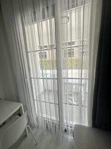 a room with a large window with white curtains at Cicek Apart Hotel in Çeşme