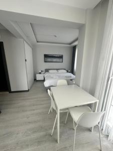 a room with three beds and a table and chairs at Cicek Apart Hotel in Çeşme