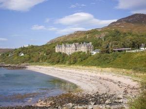 ゲイロックにあるGairloch Hotel 'A Bespoke Hotel'の丘の上の大きな建物のある海岸