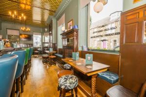 a restaurant with tables and chairs and a bar at Neidpath inn in Peebles