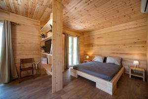 a bedroom with a bed in a wooden cabin at Redon Marias House 1 in Ágios Matthaíos