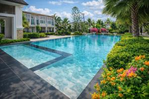 a swimming pool in a villa with flowers at H3 Villa for 14 with Pool Gym and Loft Bed near Safari World in Ban Bang Chan