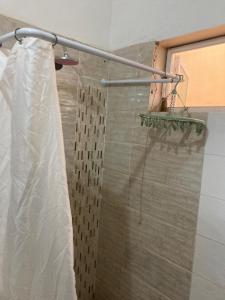 a shower with a shower curtain in a bathroom at Zahra Résidence in Rufisque