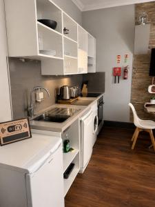 a kitchen with white cabinets and a sink and a stove at The Bromley's in Great Yarmouth