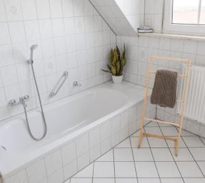 a white bathroom with a tub and a plant at Ferienwohnung Weigl Komfort in Nittenau +22 photos