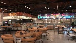 a restaurant with tables and chairs and a bar at Edge Riyadh Al Rabie in Riyadh