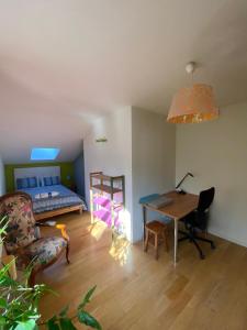 a bedroom with a bed and a desk and a table at Villa des écureuils in Dole