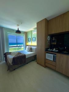 a bedroom with a bed and a view of the ocean at Flat Mandai Cabo Frio in Cabo Frio