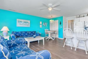 a blue living room with a couch and a table at Pebble Beach I-211 in Emerald Isle