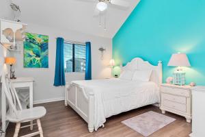 a bedroom with a white bed and a blue wall at Pebble Beach I-211 in Emerald Isle +61 photos