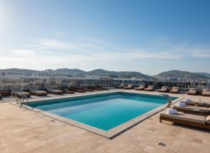 a swimming pool on the roof of a building with chairs at Uma Premium in Ulcinj