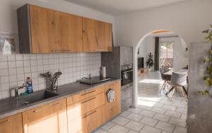 a kitchen with wooden cabinets and an arched doorway at Ferienwohnung Weigl Komfort in Nittenau