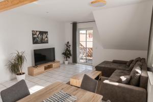 a living room with a couch and a television at Ferienwohnung Weigl Komfort in Nittenau