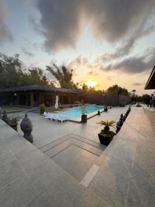 a large swimming pool with a sunset in the background at DE PORCH in Bolinao