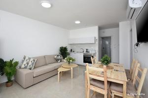 a living room with a couch and a table at MeravSuite in Migdal