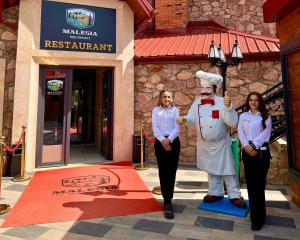 a couple of women standing next to a statue of a chef at Malesia Eko Resort in Peje