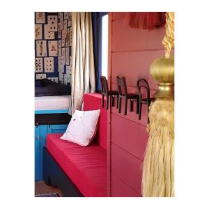 a room with a red bench with a pillow on it at La roulotte MAGIC ! des Grillots in Beaulon
